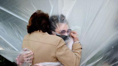 A woman hugs her grandmother through a plastic sheet in New York, in May 2020.