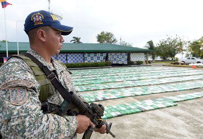 A member of the Colombian military stands next to a cocaine haul in the city of Turbo.
