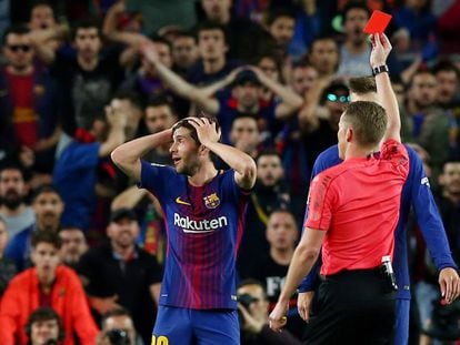 A referee shows a red card to Barcelona's Sergi Roberto.