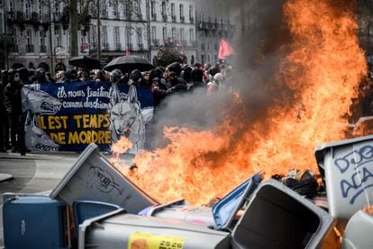 A trash container is set on fire at a protest against the French government's pension reform plan in Nantes.