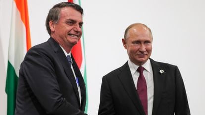 Brazil's President Jair Bolsonaro (l) and Russia's President Vladimir Putin shake hands ahead of a BRICS meeting.