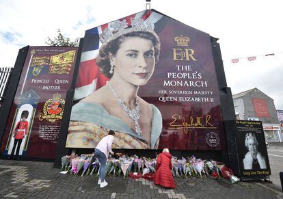 Members of the public leave flowers at a mural of Her Majesty the Queen on the Shankill road on September 9, 2022 in Belfast,
