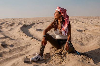 Mariel Galán sentada en las dunas del desierto de Qatar.