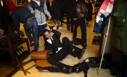 A security guard topples over as demonstrators invade a branch of Zara in Barcelona on Wednesday.