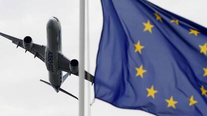 An aircraft flies past the EU flag at the Paris Air Show.