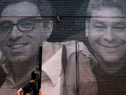 A woman steps through a door that is covered by a mural depicting American hostages and wrongful detainees who are being held abroad, July 20, 2022, in the Georgetown neighborhood of Washington.