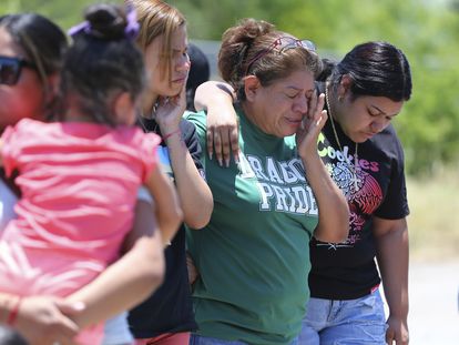 María López wipes away tears as she joins her daughters Alyssa and Marisa near the scene where 53 migrants were found dead inside a tractor trailer.
