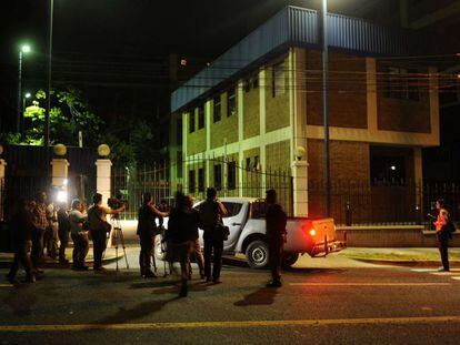 Reporters wait outside police headquarters in San Salvador.