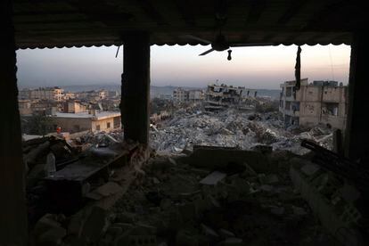 Collapsed buildings are seen through the windows of a damaged house following a devastating earthquake in the town of Jinderis, Aleppo province, Syria, on February 9, 2023.