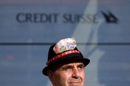 A protester adorns his hat with pictures of Swiss franc banknotes outside the Credit Suisse headquarters in Zurich on Monday. 