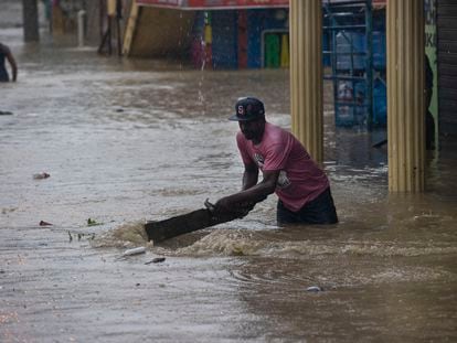 A resident today removes debris in a street flooded due to the passage of tropical storm Franklin, in Santo Domingo, on Aug. 23, 2023.