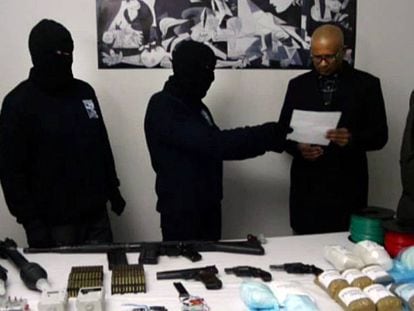 Hooded ETA members hand over an inventory of weapons to a verification group in February 2014.