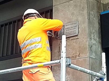 A worker removes a Franco-era plaque in Còrsega street.