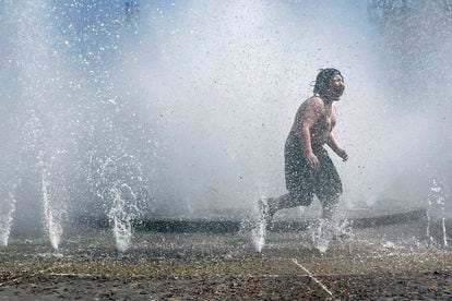 child plays in a fountain to cool off in downtown Portland, Oregon