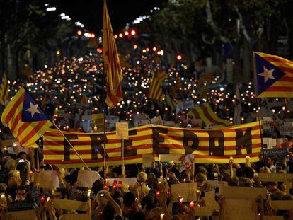 People hold a Catalan flag during candle-lit demonstration in Barcelona on October 17, 2017.