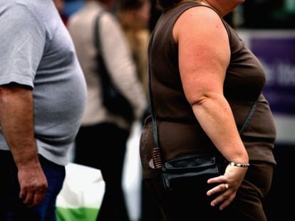 Two people living with obesity walk down a street in Glasgow, Scotland.