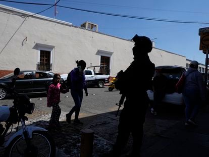 A municipal police officer watches the streets in Maravatío, a city in the Mexican state of Michoacán, after the murder of two mayoral candidates, on February 27, 2024.
