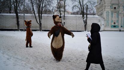 Two men dressed as bears try to drum up business for souvenir photographs in a downtown Kyiv square where the Christmas market is usually held. 