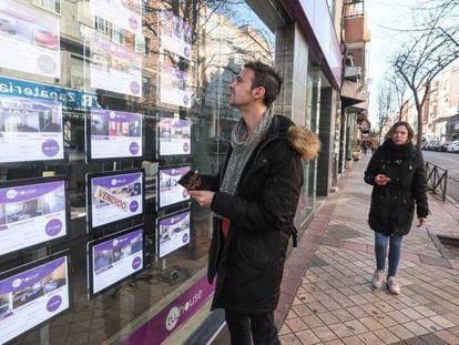 A young man reads property listings in Madrid.