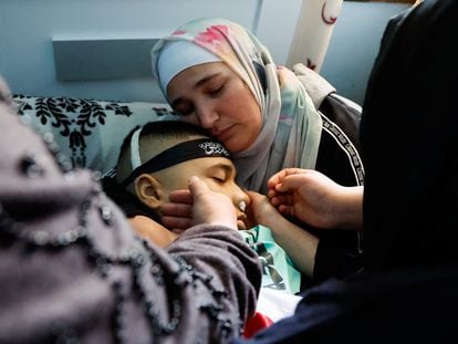 A Palestinian woman hugs her 14-year-old son, killed by an Israeli attack, during his funeral in Tubas, in the West Bank, on Tuesday.