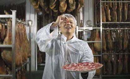 A distributor for the Spanish company Embutidos Fermín tries a piece of ham.