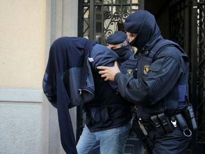 Police with one of the suspects arrested in Barcelona.