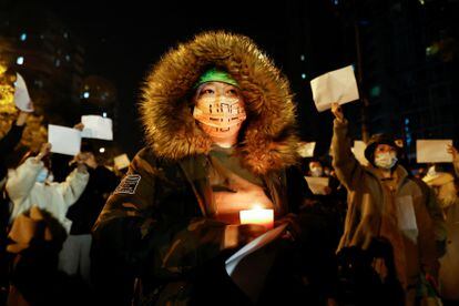 A person holds a candle during a protest in Beijing on November 27.