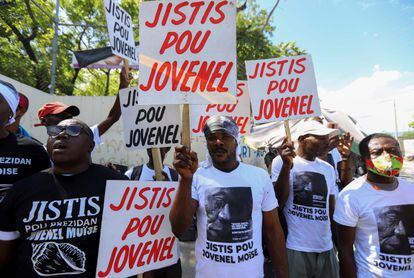 Demonstrators hold signs reading "Justice for Jovenel"