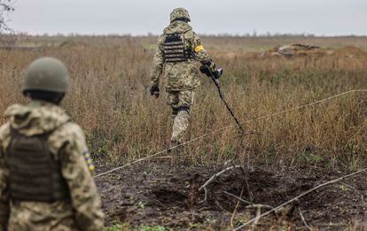 Ukrainian soldiers search for explosives in a recaptured area in the north of Kherson, Ukraine, 25 October 2022.