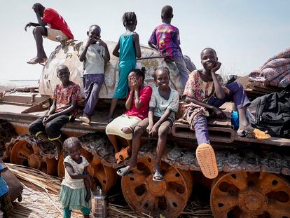 Children sit on the remains of a tank at the river port in Renk, South Sudan on May 17, 2023.