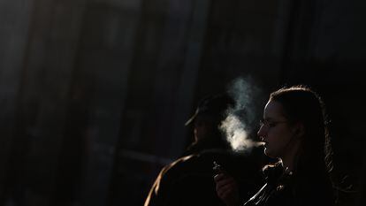 A woman smokes on a street in Krakow in March.
