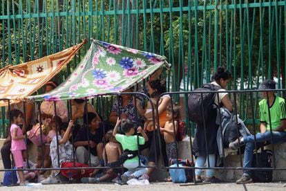 A group of migrants shelters from the sun and heat outside an immigration office on May 5.