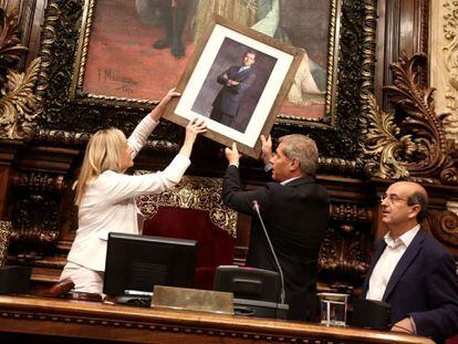 The PP leader in Barcelona, Alberto Fernández Díaz, places the portrait of Felipe VI inside city council.