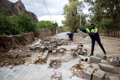 Local police remove blocks from a wall demolished by heavy rains this Thursday in the Runes neighborhood in Blanca, Murcia.