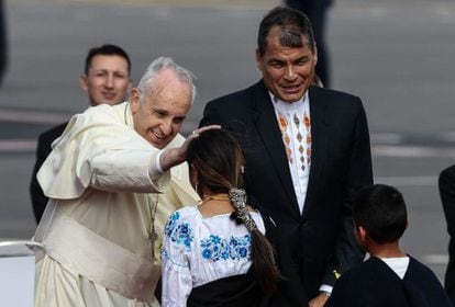 Pope Francis greets children as Ecuadorian President Rafael Correa looks on.