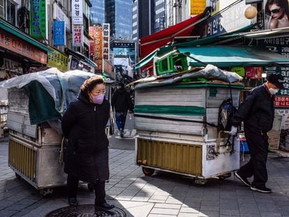 Vendors drag their street stalls along a lane in Namdaemun market in Seoul on March 13, 2023.