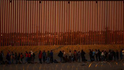Migrants seeking asylum in the United States gather near a border wall on the banks of the Rio Bravo, on the border between the U.S. and Mexico, on Sept. 19, 2023.