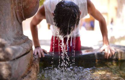 A young man tries to stay cool at a fountain inside the Mosque-Cathedral of Córdoba.