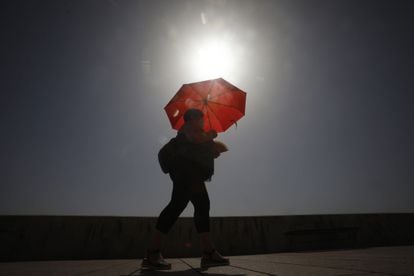 A woman shades herself from the sun in Córdoba in Andalusia.