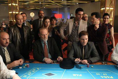 A scene from The Pelayos, with the actors Lluís Homar and Daniel Brühl seated at the table.