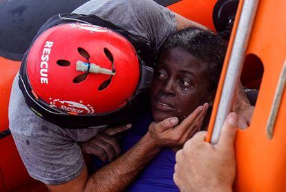 A crew member of NGO Proactiva Open Arms rescues a woman named Josephine.