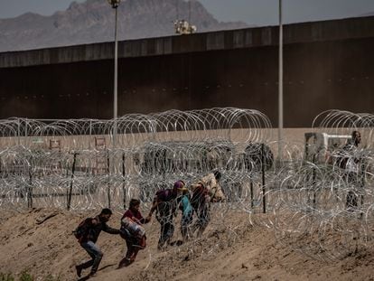 Migrants crossing barbed wire fences to turn themselves in to the U.S. Border Patrol in Ciudad Juárez.
