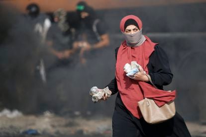 A woman with stones in her hand during a clash between Palestinians and Israeli forces at the northern entrance to Ramallah (West Bank), on October 20.