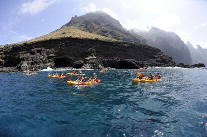 Tourists on kayaks in front of Los Gigantes cliff in Tenerife (Canary Islands).