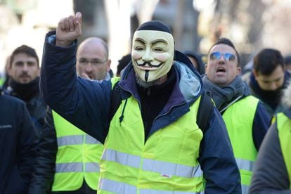 A taxi driver wearing a Guy Fawkes mask and a yellow vest during a strike in Barcelona.
