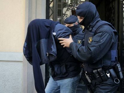 Two Mossos take off a suspect of Brussels terror attacks in Barcelona.