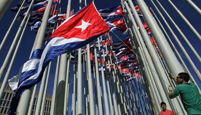 Workers hoist Cuban flags outside the US Interests Section in Havana on December 30.