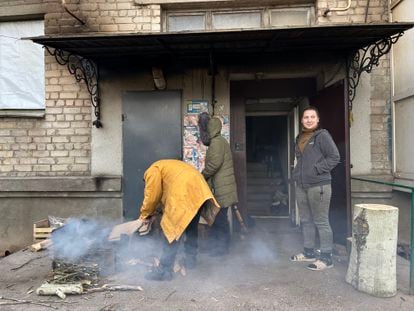 Residents of Bakhmut warm themselves on fires outside their homes on Wednesday.