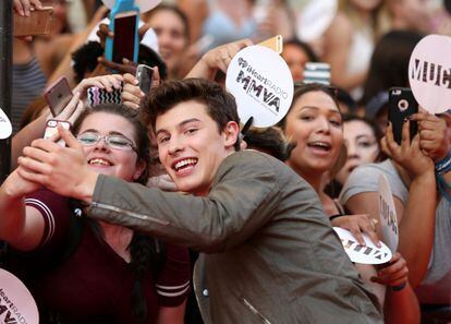 Singer Shawn Mendes surrounded by fans.