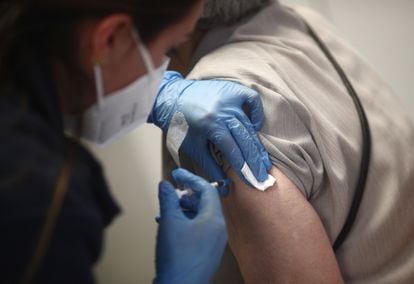 A health worker administering the first shot of the Pfizer vaccine in Madrid.
